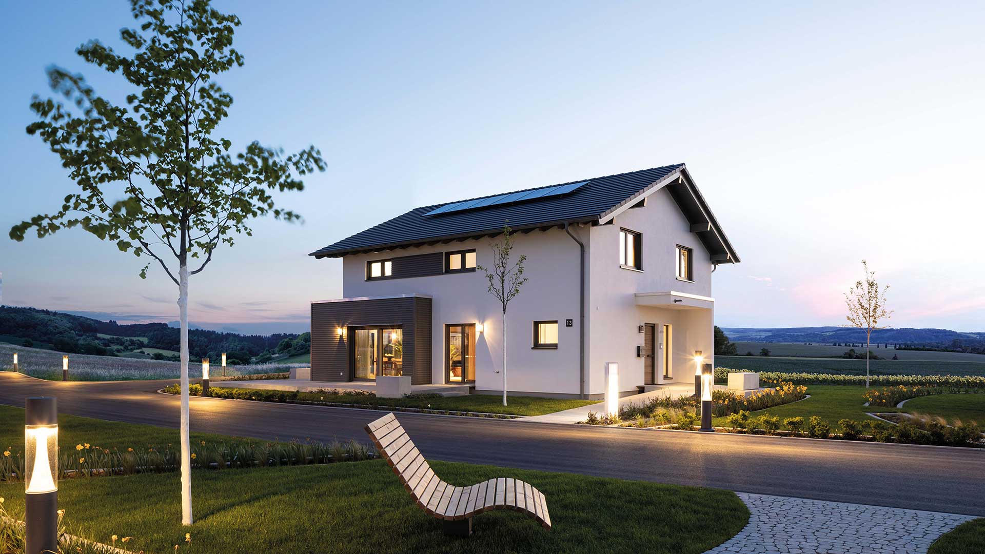 Modernes Fertighaus mit nachhaltiger Bauweise von FingerHaus, abends beleuchtet.